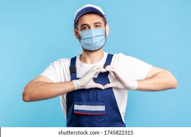 Love Our Customers! Handyman In Overalls, Mask And Gloves Showing Heart Gesture And Smiling Friendly To Camera. Profession Of Service Industry, Courier Delivery, Housekeeping Maintenance. Isolated