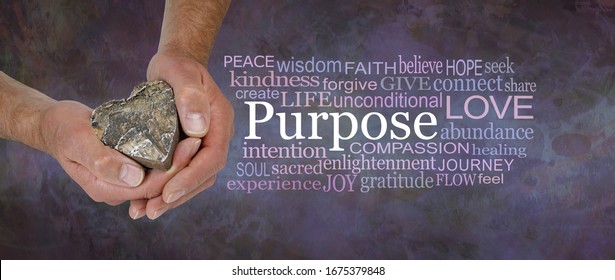 Love Is Our True Soul Purpose - Male Hands Holding A Wooden Love Heart Beside A PURPOSE Word Cloud Against A Rustic Dark Purple Brown Stone Grunge Background
                               