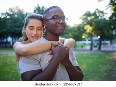 Love, peace or couple of friends hug in a park bonding on a relaxing romantic date in nature together. Interracial, young black man and happy woman embrace enjoying quality time on a holiday vacation - Shutterstock ID 2256589537