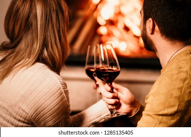 In Love People Having A Glass Of Wine By The Fireplace And Enjoying A Lovely Evening At Home