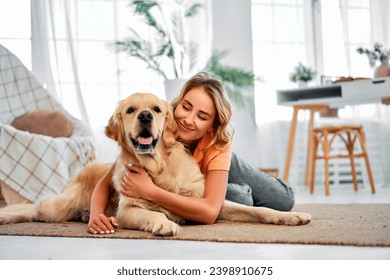 Love to pet. Adorable woman with closed eyes embracing adult golden retriever while lying together on floor. - Powered by Shutterstock