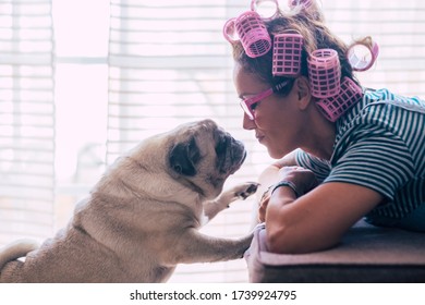 Love and pet therapy concept with home scene woman and best friend dog kissing and looking - romantic pug and female situation - life with animals during lockdown