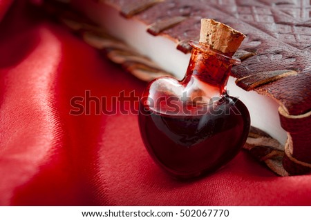 Love potion leaning on a book of magic spells for Valentine's day [[stock_photo]] © 