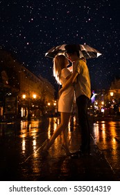 Love In The Rain / Silhouette Of Kissing Couple Under Umbrella