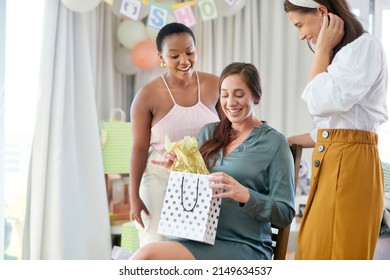 I love receiving gifts. Shot of a pregnant mother to be receiving gifts from her friends at her baby shower. - Powered by Shutterstock