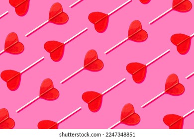 Love retro pattern for Valentine's Day and romantic dates. Candy heart lolipop abstract love relationship concept. Festive pattern of traditional red heart shaped lollipops. flat lay