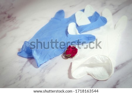Love and romance in coronavirus era -   man and woman gloves, red rose and wedding ring