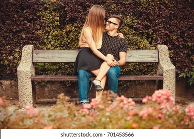 Love Romance Flirt Dating Concept. Affectionate Couple Sitting On Bench. Young Girl Sitting On Her Boy Lap. 