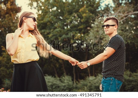 Love romance relationship dating concept. Cheerful girl holding hands in park. Young girl and boy taking walk.