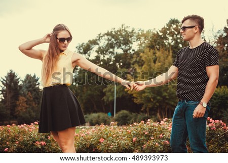 Love romance relationship dating leisure.Youthful couple spending time together. Young girl and boy olding hands in park. 