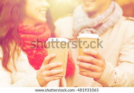 love, season, drinks and people concept - close up of happy smiling couple with coffee cups in autumn park