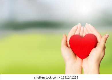 Love Shape Exercise Ball On Female Woman Hand Support On Aging Old Wood Background: Heart Disease Awareness Week: American Heart Month: National Wear Red Day For Women Heart Health Concept