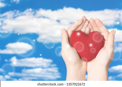 Love Shape Exercise Ball On Female Woman Hand Support On Aging Old Wood Background: Heart Disease Awareness Week: American Heart Month: National Wear Red Day For WomenÃ¢â‚¬â„¢s Heart Health Concept