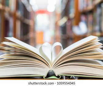 Love Story Book With Open Page Of Literature In Heart Shape And Stack Piles Of Textbooks On Reading Desk In Library, School Study Room For National Library Lovers Month  And Education Learning Concept