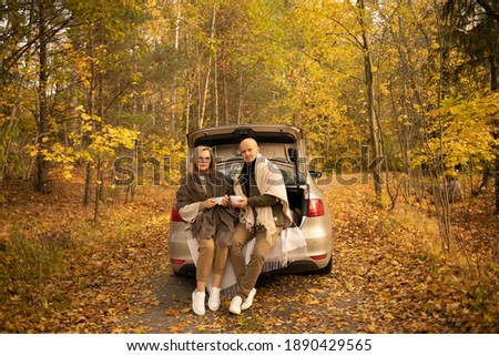 love story with a dog in a car in autumn in the forest