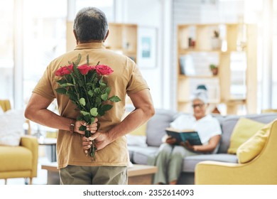 Love, surprise and senior man with roses behind back for romance, gratitude and commitment to wife in living room of home. Couple, person and flowers in hand for gift and marriage anniversary - Powered by Shutterstock