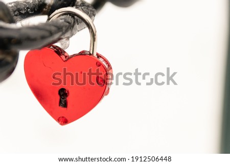 Love for sweethearts and relation memory in form of a lock as symbol for love, romance, eternity and endless love for couples on Valentines Day at a chain fence to celebrate wedding or romantic day