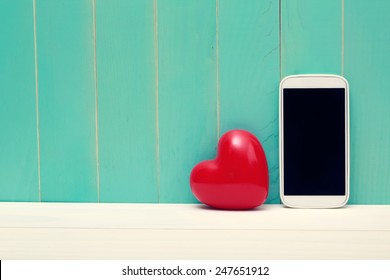 Love and technology theme with big red heart and smart phone - Powered by Shutterstock