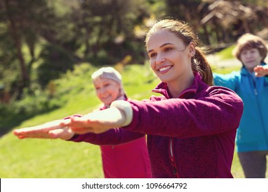 I love training. Joyful sportive woman smiling and training aged people in the open air - Shutterstock ID 1096664792