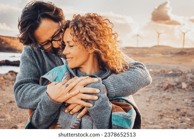 Love and travel people together. One man hug woman from behind in romantic outdoor leisure activity together. Desert scenic landscape in background with windmills and sunset time. Adventure traveler - Powered by Shutterstock