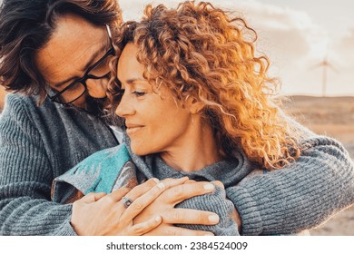Love and travel people together. One man hug woman from behind in romantic outdoor leisure activity together. Desert scenic landscape in background with windmills and sunset time. Adventure traveler - Powered by Shutterstock