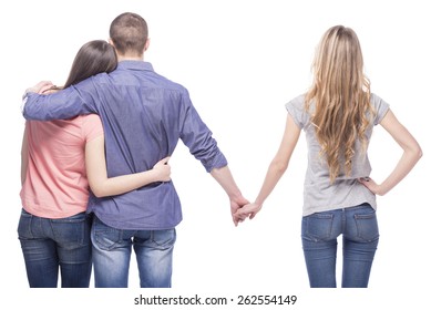 Love triangle. Handsome man embrace his girlfriend while holding hands with another girl. isolated on white background.