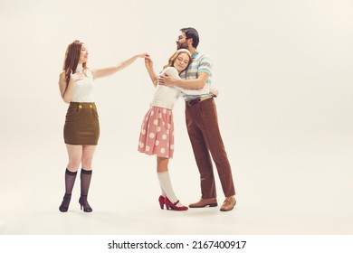 Love Triangle, Intrigue. One Young Man And Two Girl In Vintage Retro Style Outfits Psoing Isolated On White Background. Concept Of Relations, Family, 1960s American Fashion Style And Art.