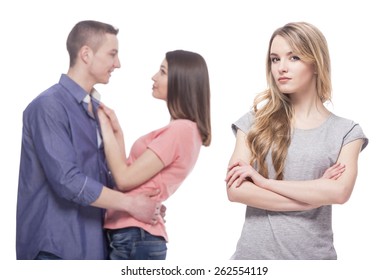 Love triangle. Loneliness. Young sad women standing with her arms crossed while another women and men hugging. isolated on white background.