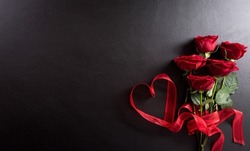 Love And Valentine's Day Concept Made From Red Rose  And Heart Ribbon On Black Wooden Background. Top View With Copy Space, Flat Lay.
