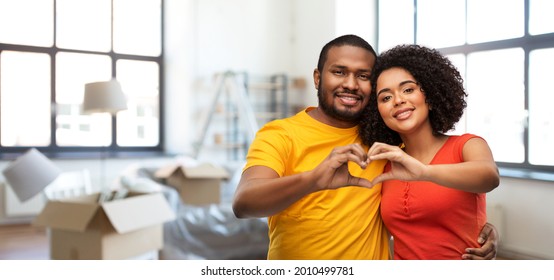 Love, Valentines Day And Moving Concept - Happy African American Couple Making Hand Heart Gesture Over New Home Background