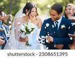 Love, wedding and couple walking with petals and guests throwing in celebration of romance. Happy, smile and young bride with bouquet and groom with crowd celebrating at the outdoor marriage ceremony