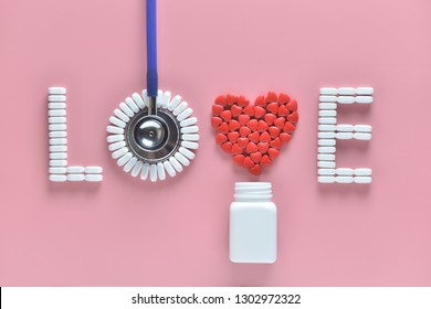 LOVE Word Made From Medicine Pills, Red Heart Shape Pouring Out Of White Bottle And Stethoscope, On Pink Background. Concept Of Valentine's Day Or Pharmacy, Medical.