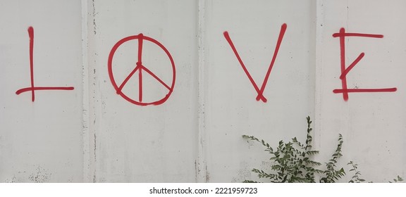 Love word  and Peace sign on grey concrete wall . inscription "love" with the sign of peace. - Shutterstock ID 2221959723