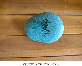 love  - words carved in natural stone, chinese letters, wooden background, top view. - Powered by Shutterstock