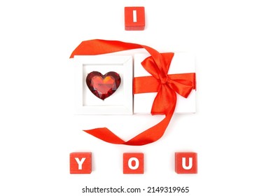 I LOVE YOU Arrangement Made Of A Huge Heart Shaped Fashion Ring In A Gift Box With A Red Bow And Toy Letter Blocks Isolated On White Background.