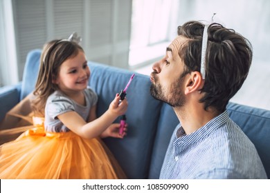 I Love You, Dad! Handsome Young Man At Home With His Little Cute Girl. Daughter Is Doing Makeup For Her Daddy. Happy Father's Day!