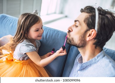 I Love You, Dad! Handsome Young Man At Home With His Little Cute Girl. Daughter Is Doing Makeup For Her Daddy. Happy Father's Day!