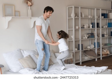 I love you, dad! Happy Father's Day! Caucasian young father daddy at home with his little daughter having fun and jumping on bed. Family time, celebration together - Powered by Shutterstock