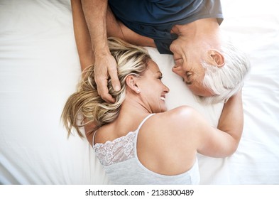 Love - you have to feel it to know what it is. Shot of an affectionate mature couple lying in bed together at home. - Powered by Shutterstock