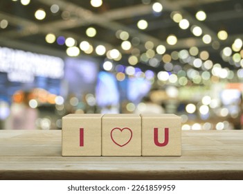 I love you letter on wood block cubes on wooden table over blur light and shadow of shopping mall, Valentines day concept