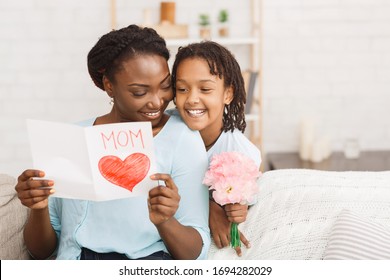 I Love You Mom. African girl congratulating her mom with pink flowers and card, free space