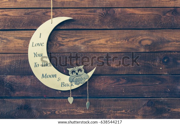 I love you to the moon and back - wording on white\
moon with owl on a rustic wooden background with place for text.\
Happy St. Valentine\'s, Mother\'s Day. Love concept. Copy space.\
Toned image.