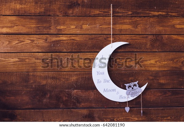 I love you to the moon and back - wording on white\
moon with owl on a rustic wooden background with place for text.\
Happy St. Valentine\'s, Mother\'s Day. Love concept. Copy space.\
Toned image.
