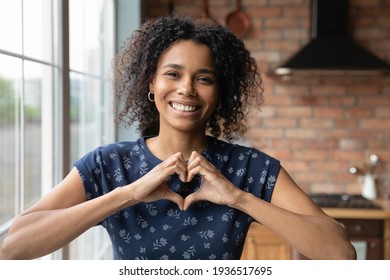I love you. Portrait of thankful young african lady blogger appreciate for support of vlog channel hold fingers joined in like sign. Headshot of loving black female looking at camera show heart symbol