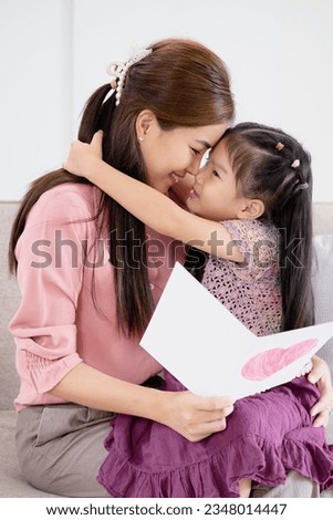 I love you. Smiling young woman getting presents from kids.  daughters giving mom handmade greeting card. Little children  kissing hugging mommy and wishing her Happy Mother's Day