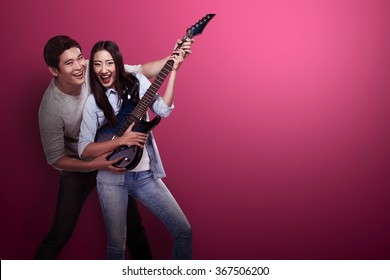 Lovely Asian Couple Playing Guitar. Valentine Day Concept