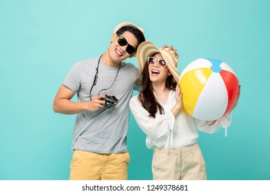 Lovely Asian couple in summer casual clothes and beach accessories studio shot isolated on light blue background - Powered by Shutterstock