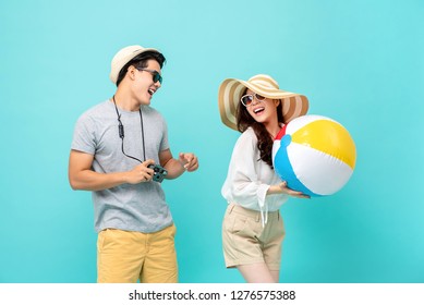 Lovely Asian couple in summer casual clothes with beach accessories studio shot isolated on light blue background - Powered by Shutterstock