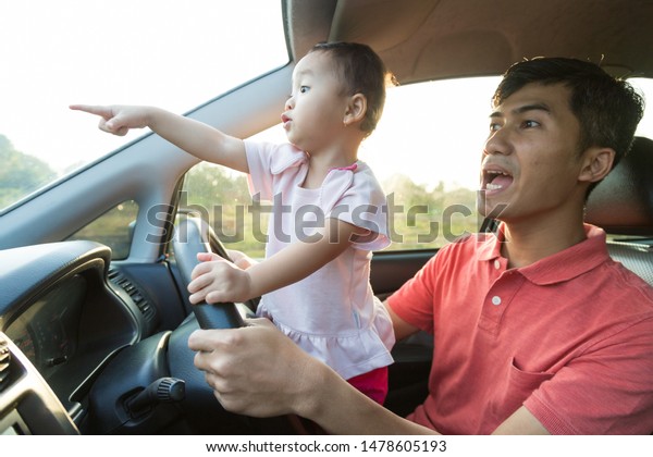 lovely asian daughter with father in the car\
playing together