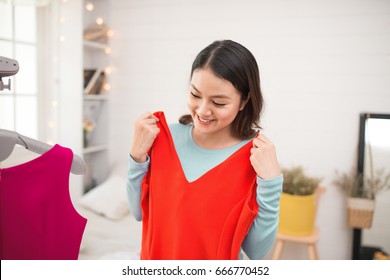 A Lovely Asian Girl Trying On New Dress At Home.